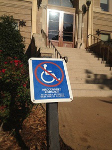 Image of no handicap accessible sign in front of stairs