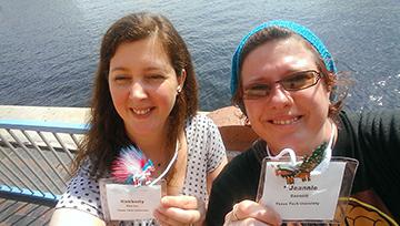 Two women are taking a selfie. They are smiling and holding up their name tags with their new sparkle ponies attached to their name tags.